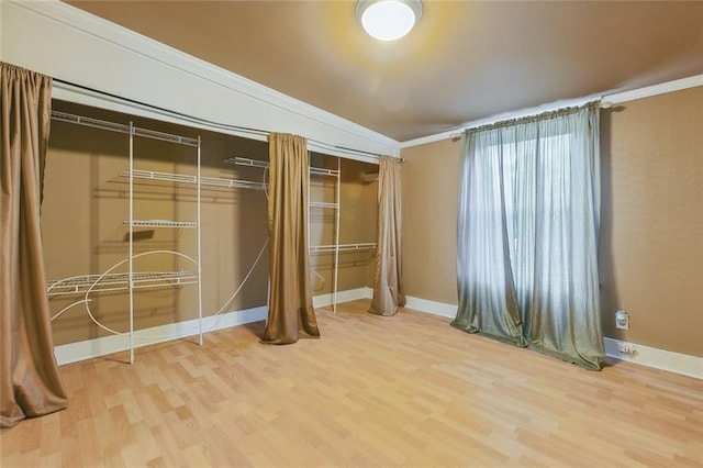 unfurnished bedroom featuring a closet, hardwood / wood-style flooring, and ornamental molding