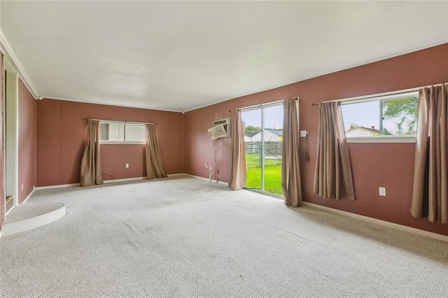 empty room featuring an AC wall unit and light colored carpet