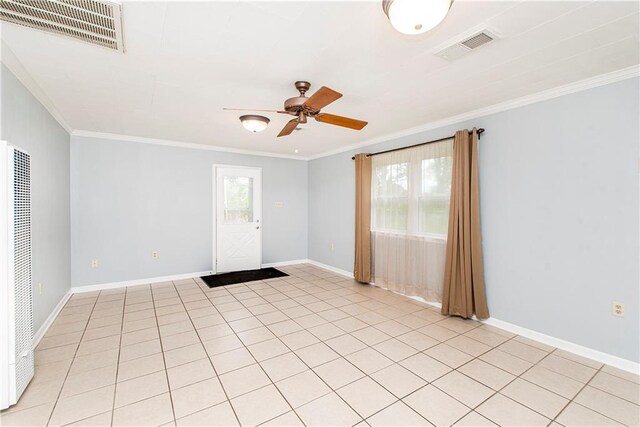 empty room featuring ceiling fan, crown molding, and light tile patterned flooring