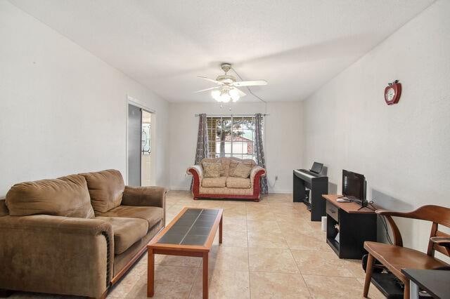 living room featuring ceiling fan and light tile patterned floors