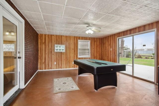 recreation room with ceiling fan, wooden walls, and billiards