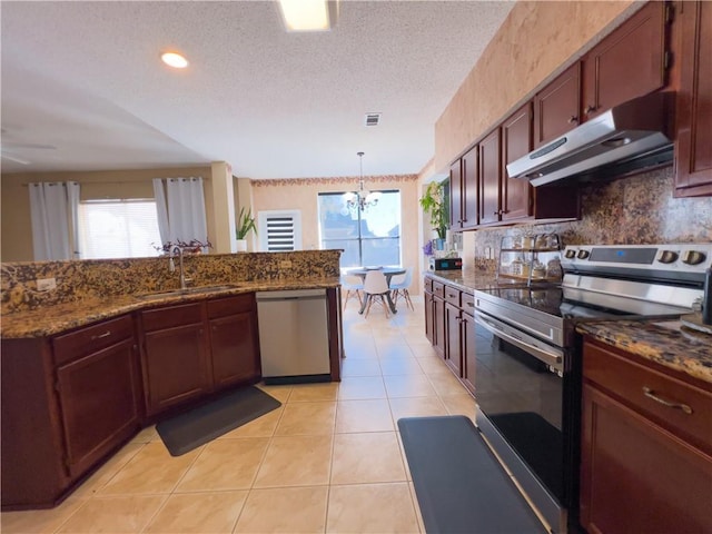 kitchen with sink, stainless steel appliances, a healthy amount of sunlight, light tile patterned flooring, and decorative light fixtures