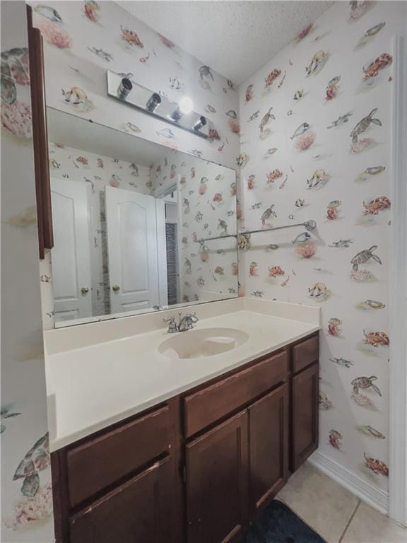 bathroom with tile patterned flooring, vanity, and a textured ceiling