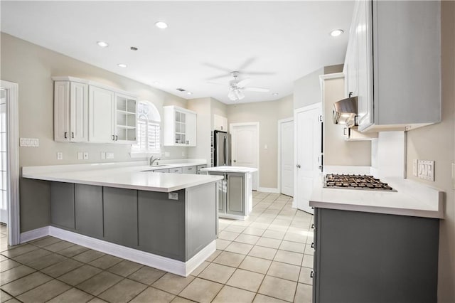 kitchen featuring a kitchen breakfast bar, appliances with stainless steel finishes, kitchen peninsula, white cabinetry, and ceiling fan