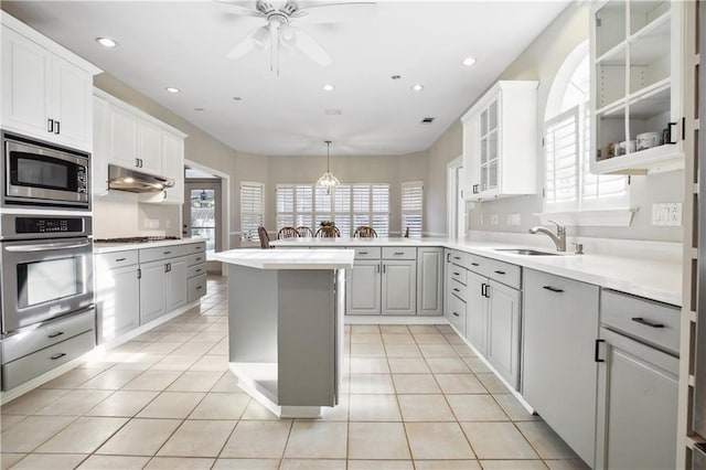 kitchen featuring recessed lighting, a ceiling fan, under cabinet range hood, stainless steel appliances, and a sink