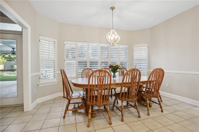 dining space with a chandelier, baseboards, and light tile patterned flooring