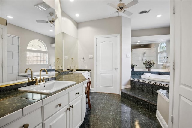 bathroom with vanity, ceiling fan, and plus walk in shower