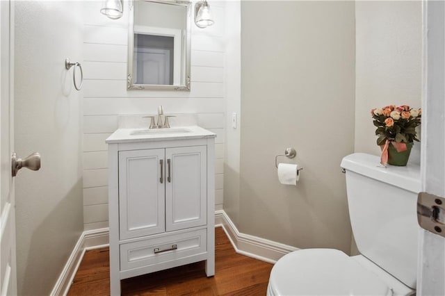 bathroom with vanity, baseboards, toilet, and wood finished floors