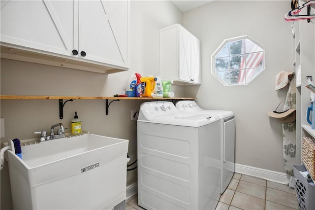 washroom with baseboards, light tile patterned flooring, independent washer and dryer, cabinet space, and a sink