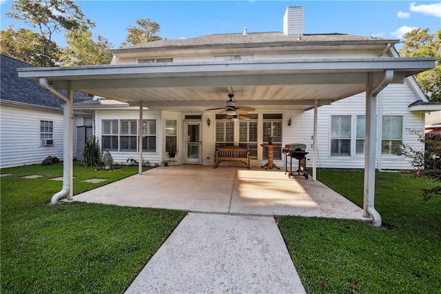 back of property featuring a shingled roof, a yard, a patio area, a ceiling fan, and a chimney