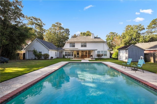 rear view of house featuring a yard, a patio area, a fenced in pool, and an outdoor structure