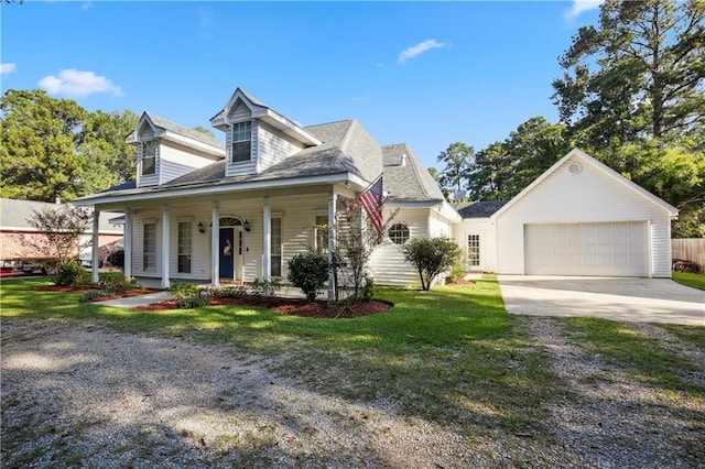 cape cod-style house featuring driveway, a garage, covered porch, and a front yard