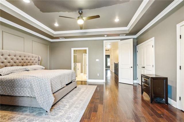 bedroom with a tray ceiling, ceiling fan, dark hardwood / wood-style floors, and ornamental molding