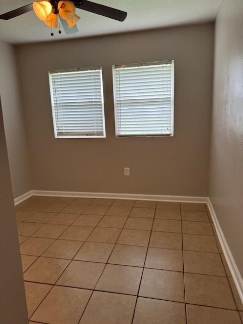 spare room with ceiling fan and light tile patterned floors