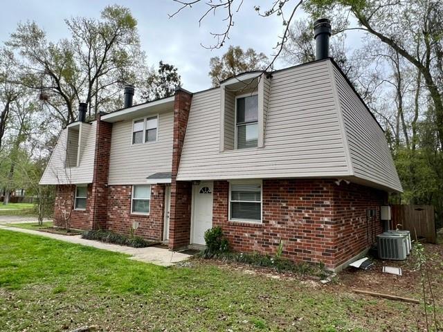 view of front of property featuring a front yard and central AC