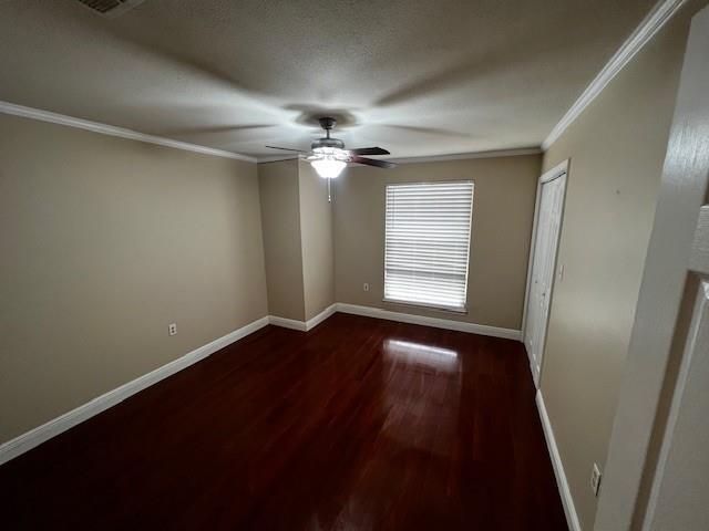 empty room featuring ceiling fan, dark hardwood / wood-style flooring, and crown molding