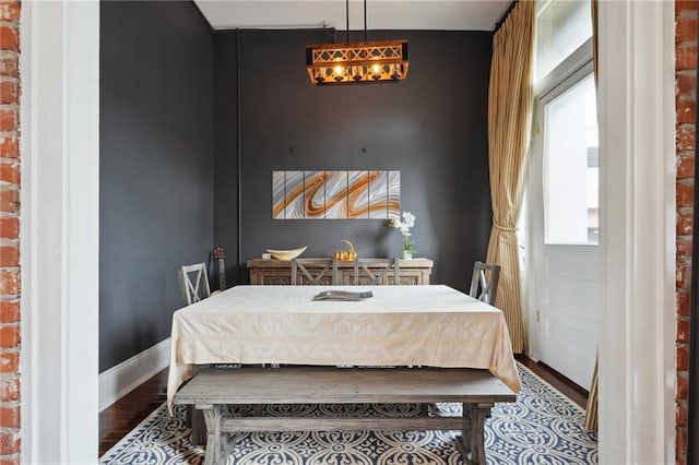 bedroom featuring hardwood / wood-style floors and brick wall