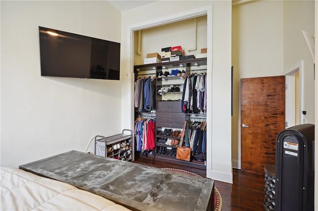 bedroom with dark wood-type flooring and a closet