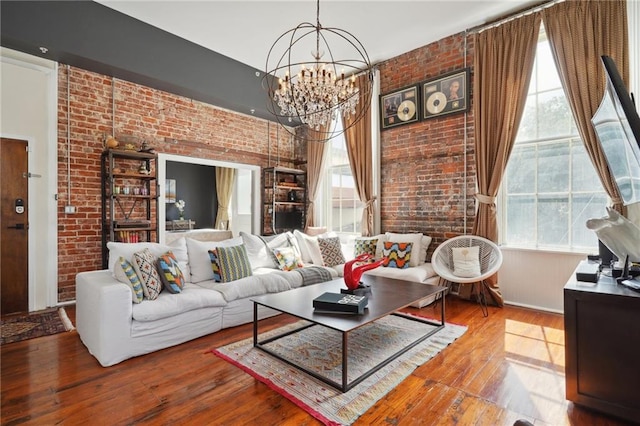 living room featuring plenty of natural light, hardwood / wood-style flooring, and brick wall