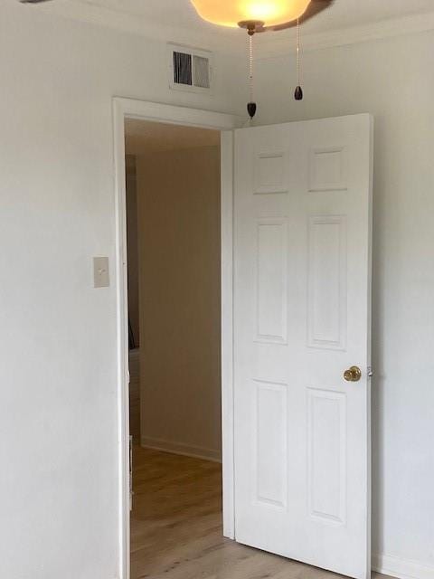 hallway featuring hardwood / wood-style floors and ornamental molding