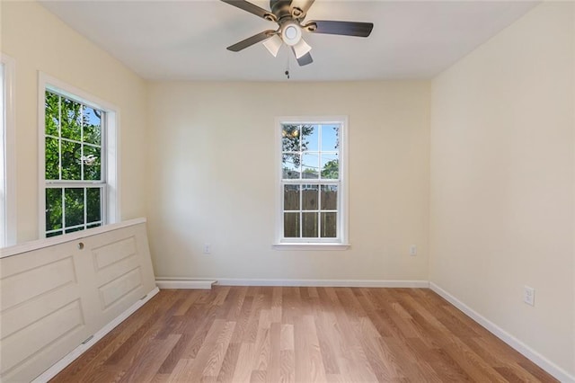 unfurnished room with plenty of natural light, light hardwood / wood-style floors, and ceiling fan