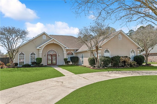 ranch-style home with a front yard and french doors