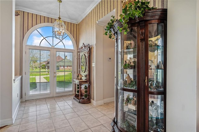 tiled foyer entrance featuring crown molding, an inviting chandelier, and french doors