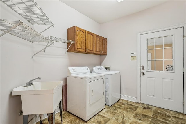 clothes washing area featuring cabinets, sink, and washing machine and dryer