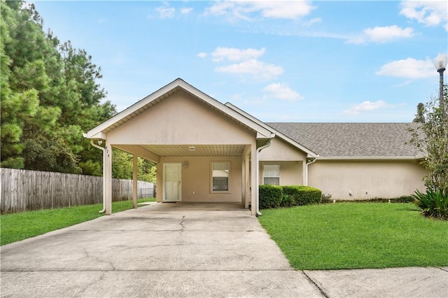 view of front of property with an attached carport, a front yard, fence, stucco siding, and concrete driveway