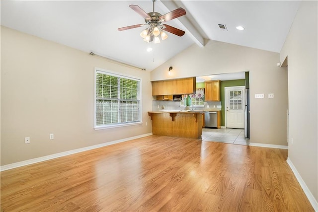 unfurnished living room with ceiling fan, lofted ceiling with beams, and light hardwood / wood-style floors