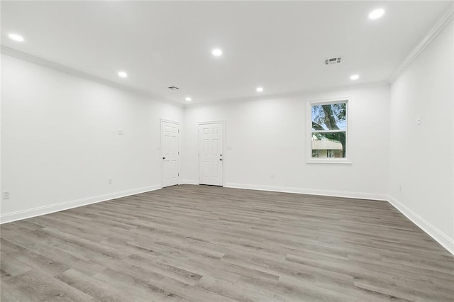 empty room featuring wood-type flooring and ornamental molding