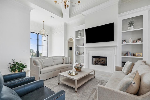 living room featuring a chandelier, crown molding, and built in features