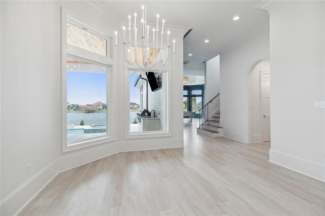 kitchen with white cabinets, pendant lighting, built in fridge, a large island, and a chandelier