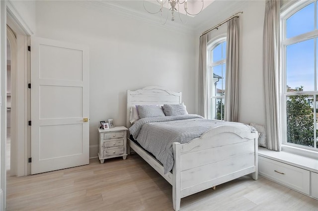 bedroom with light hardwood / wood-style flooring, crown molding, a chandelier, and multiple windows