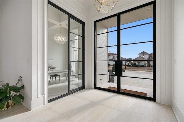 doorway with wood-type flooring and a chandelier