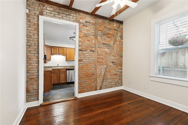 interior space featuring beamed ceiling, ceiling fan, dark wood-type flooring, and brick wall