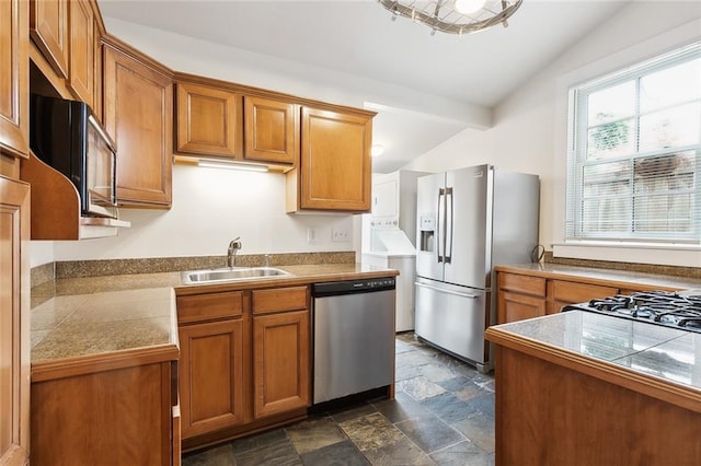 kitchen featuring vaulted ceiling, stainless steel appliances, sink, and a healthy amount of sunlight