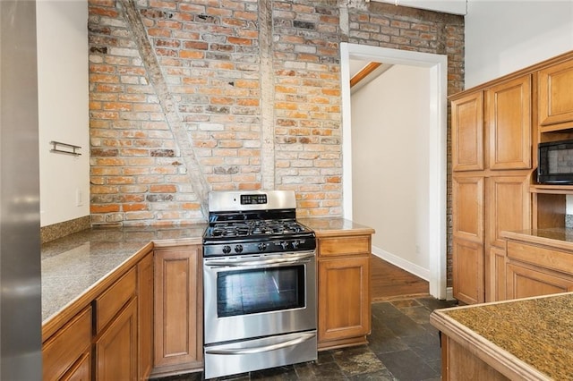 kitchen featuring brick wall, dark wood-type flooring, and stainless steel range with gas stovetop