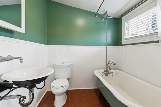 bathroom featuring sink, hardwood / wood-style floors, toilet, and a bath