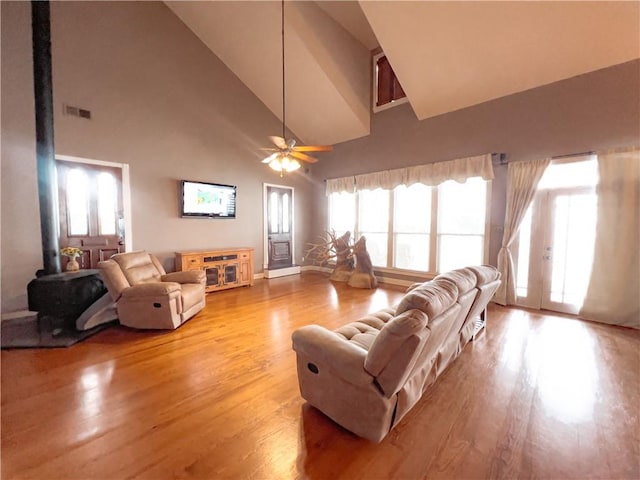 living room featuring light wood-type flooring, high vaulted ceiling, and ceiling fan