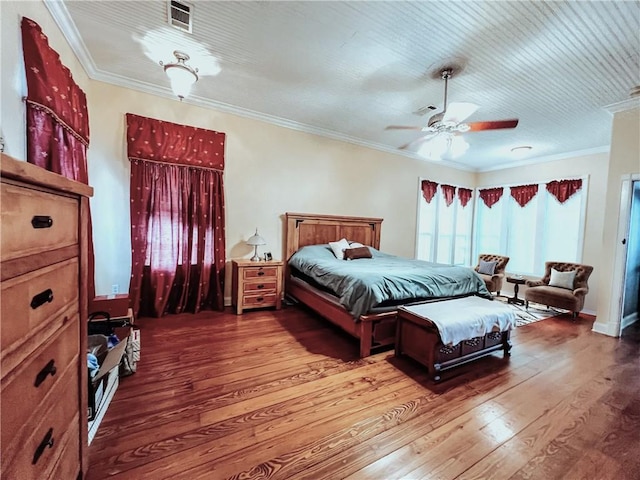 bedroom with hardwood / wood-style flooring, ceiling fan, and ornamental molding