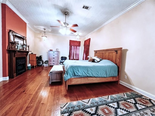 bedroom with ceiling fan, hardwood / wood-style floors, and ornamental molding