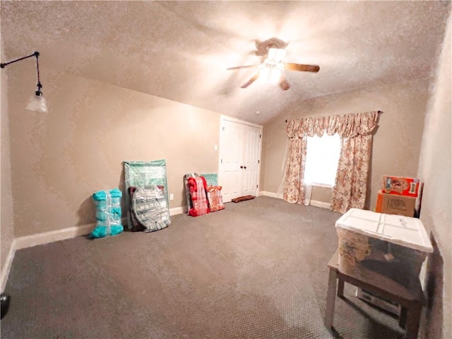 interior space with ceiling fan, carpet floors, a textured ceiling, and vaulted ceiling