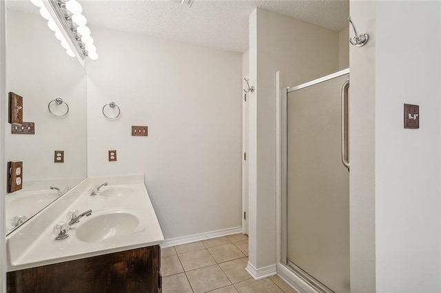 bathroom featuring vanity, an enclosed shower, a textured ceiling, and tile patterned floors