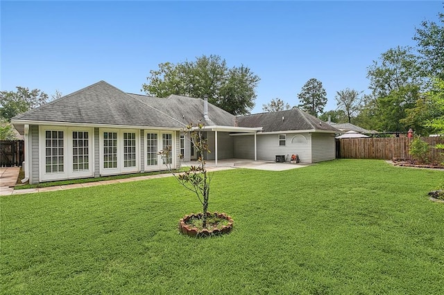 back of property with a lawn, a patio area, and french doors