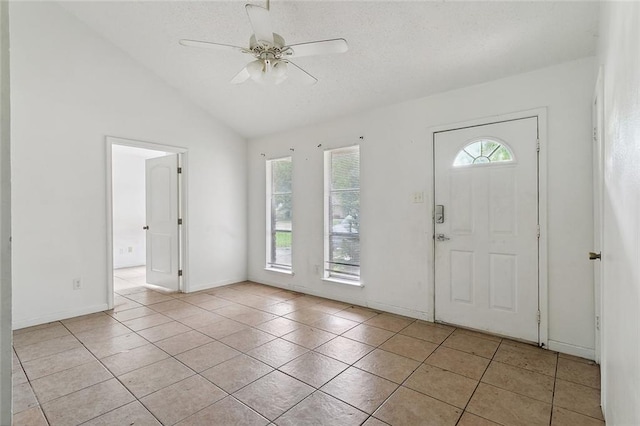 entrance foyer with lofted ceiling, light tile patterned flooring, and ceiling fan