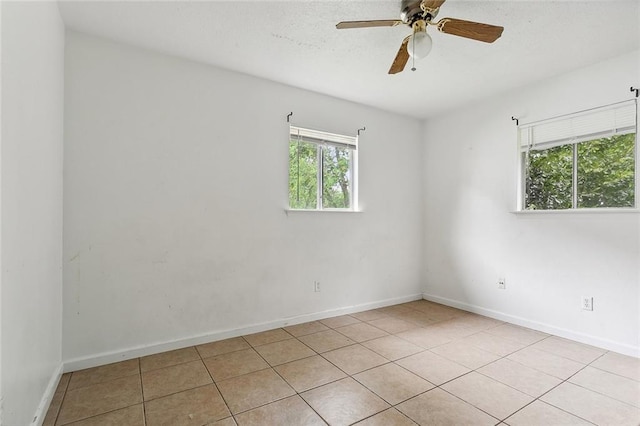 empty room with ceiling fan and light tile patterned flooring