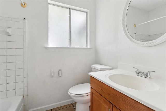 full bathroom featuring tile patterned flooring, toilet, tiled shower / bath, and vanity