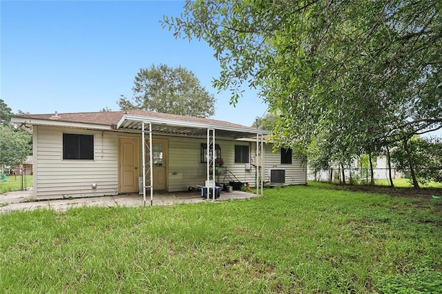 back of property with a lawn, a patio, and central air condition unit