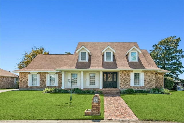 new england style home featuring a front yard